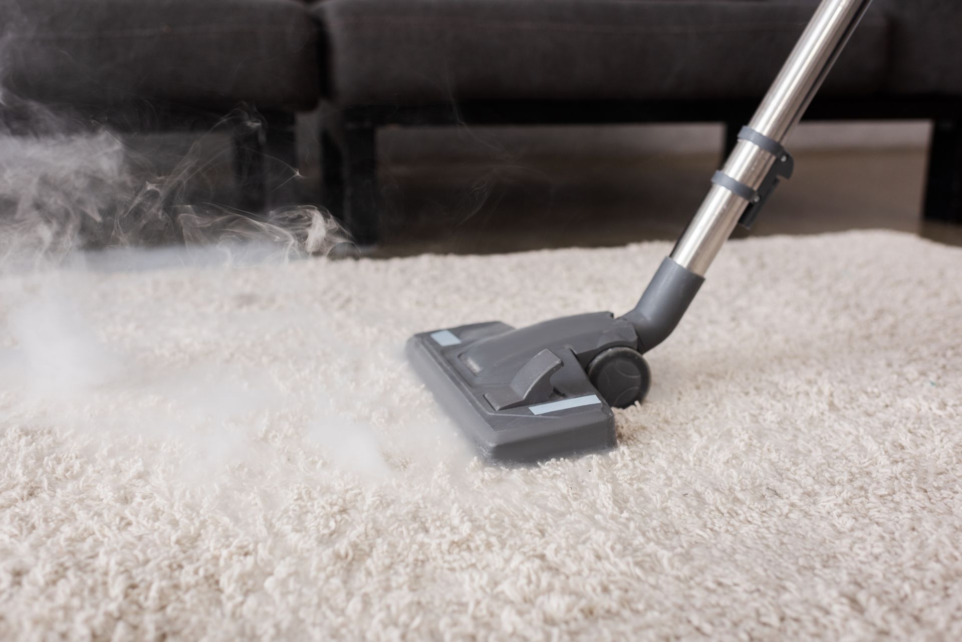 Cleaner wiping a cloth along grout lines between tiles to remove dirt and stains, revealing a cleaner and brighter surface.