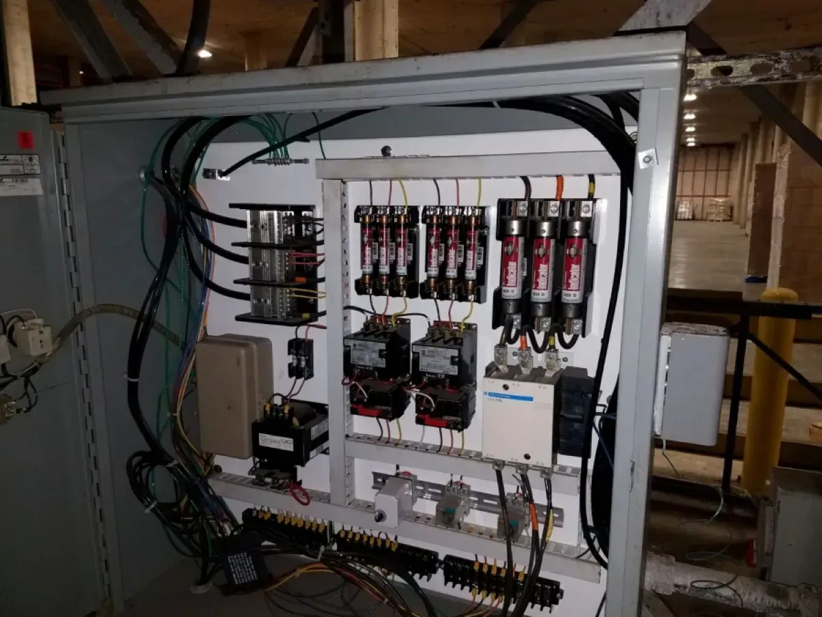 A large electrical panel with a lot of wires coming out of it