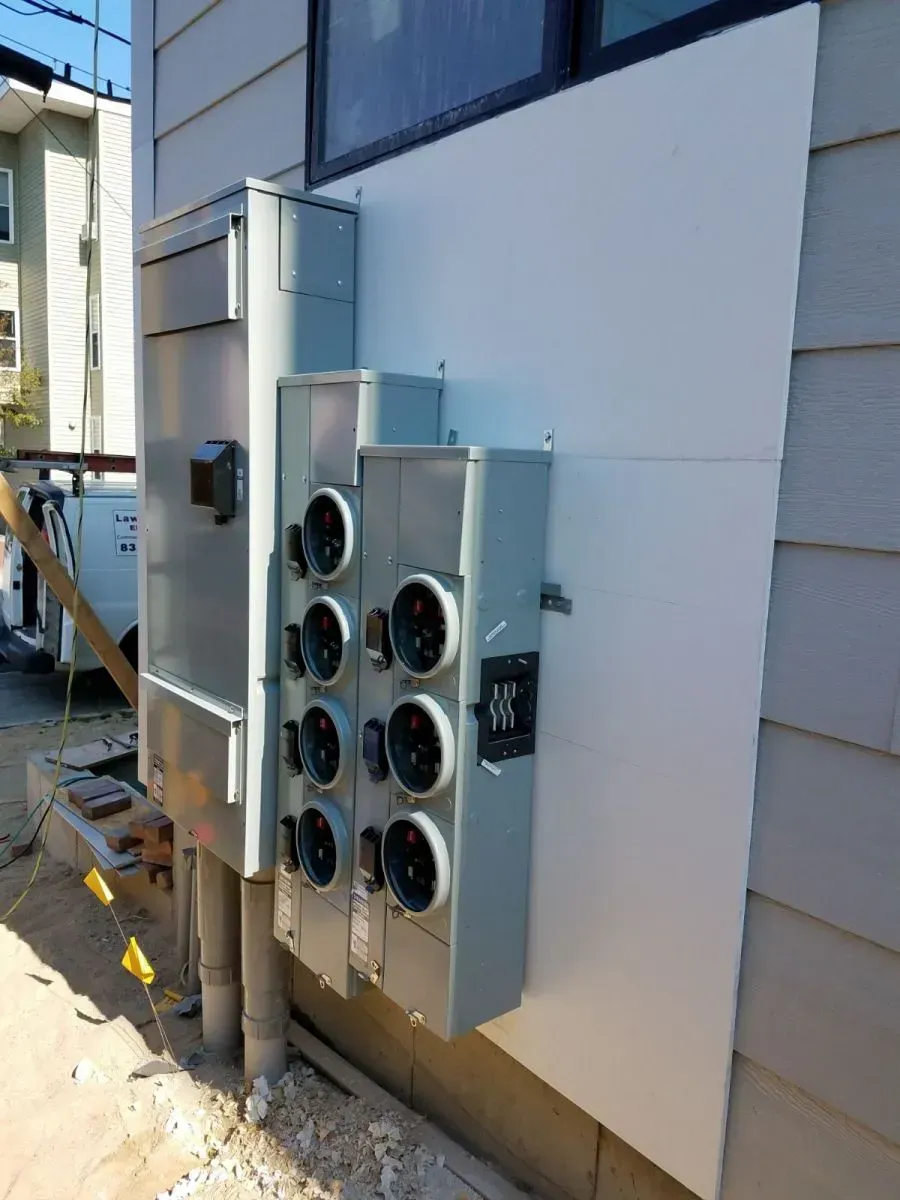 A large electrical box is attached to the side of a house.
