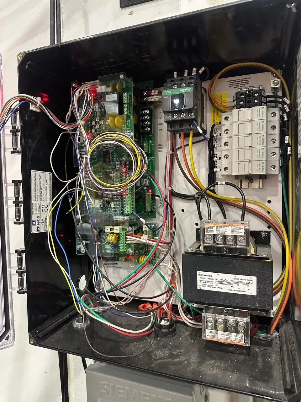 The inside of an electrical box with a lot of wires coming out of it.