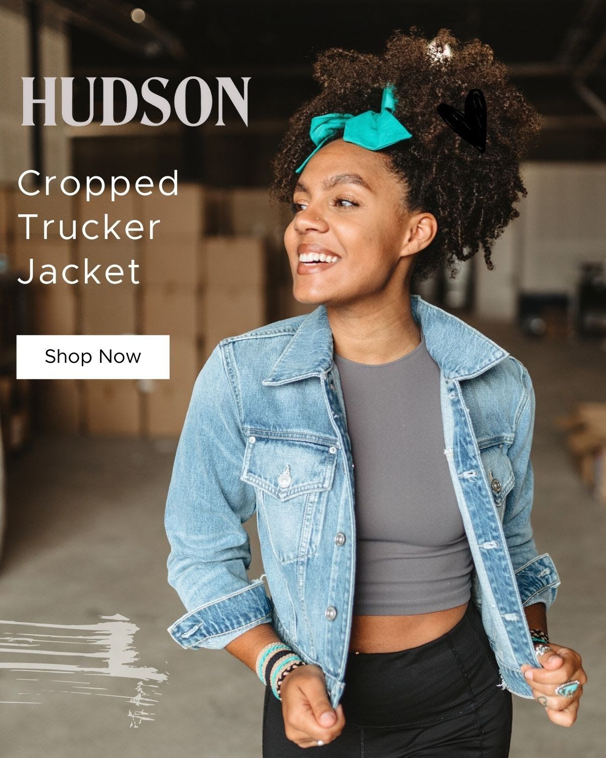 A woman is wearing a crop top and a denim jacket.