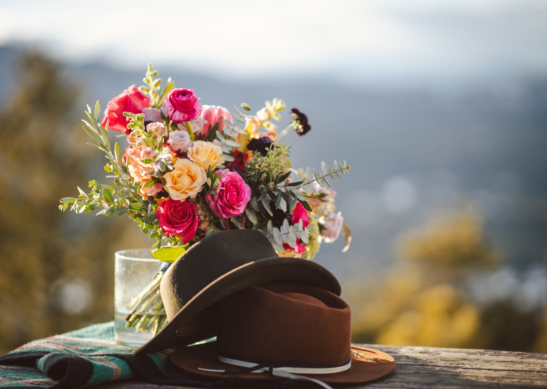 A bouquet of flowers is sitting on top of a hat on a table.