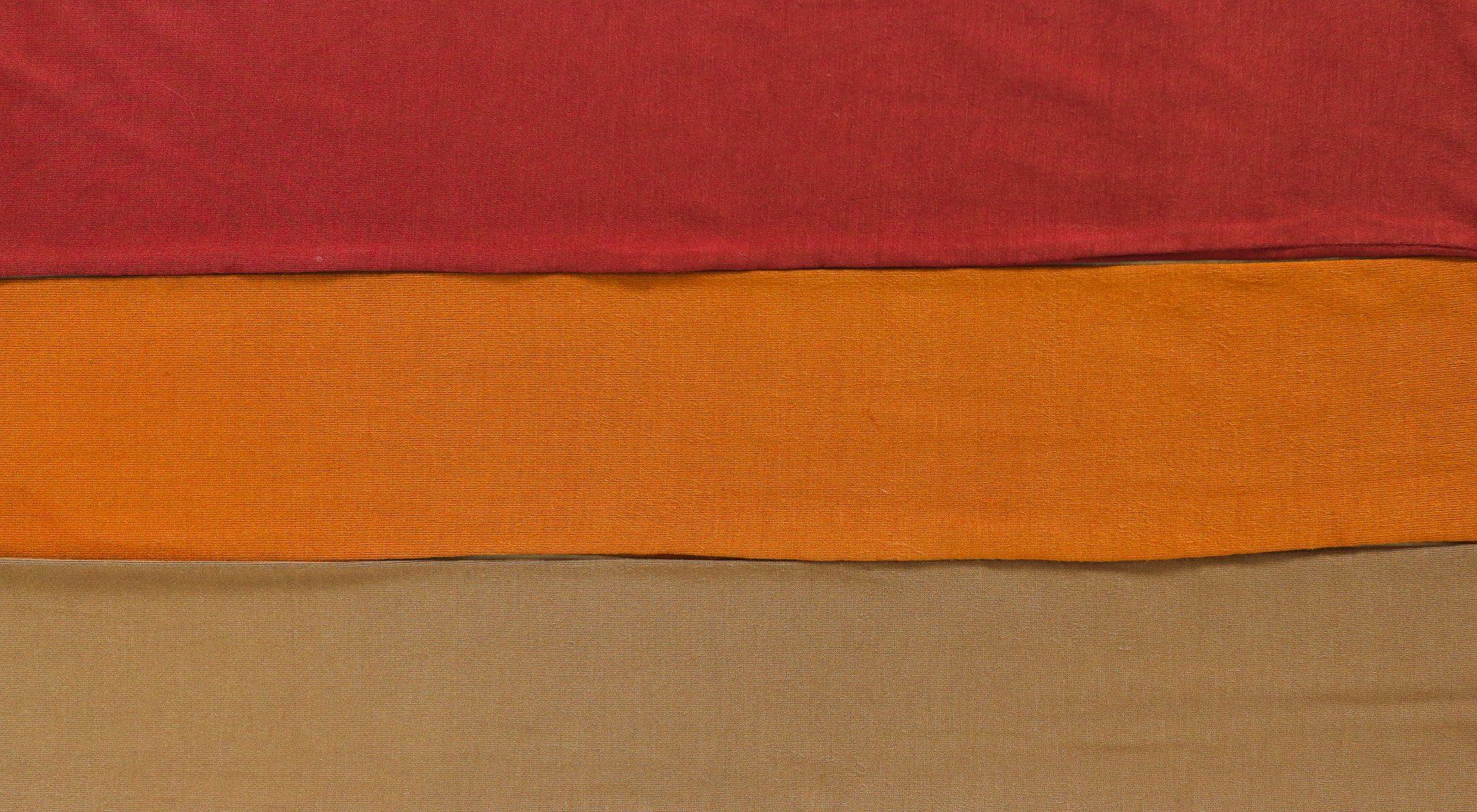 A close up of three different colored fabrics stacked on top of each other.