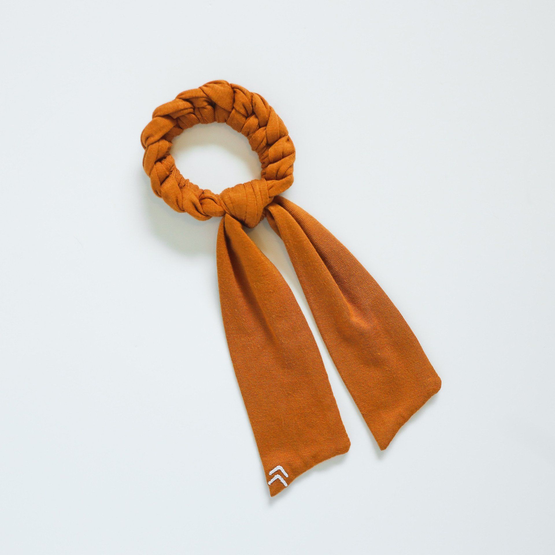 A brown scarf with a white arrow on it