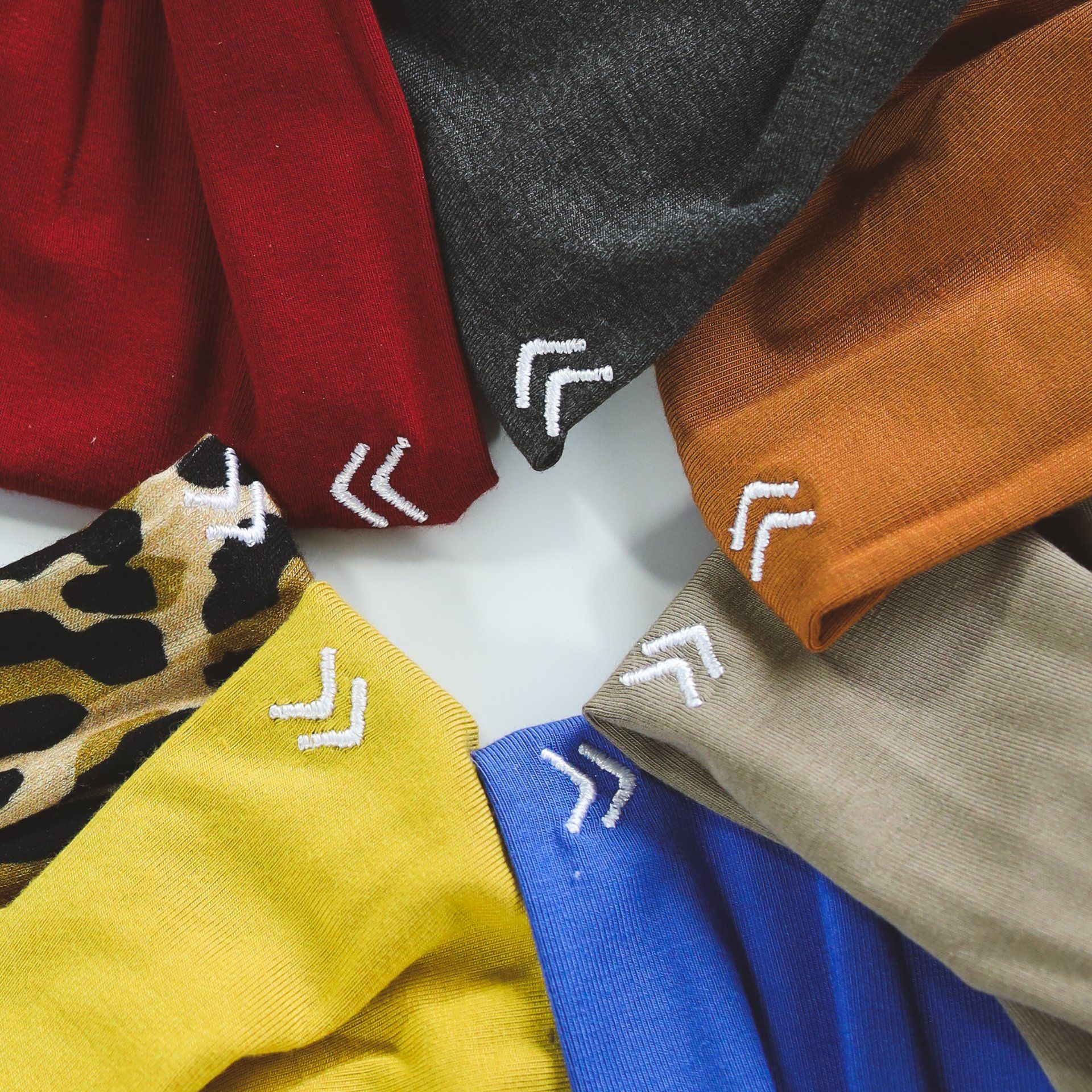 A bunch of different colored fabrics with white arrows on them