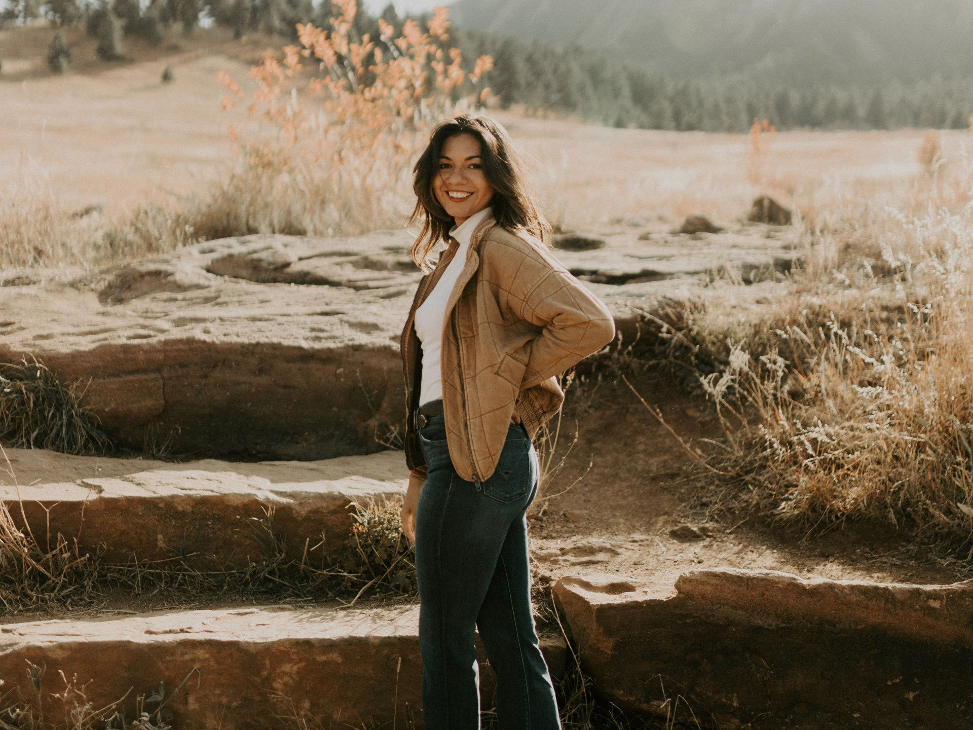 A woman is standing on a set of stairs in a field.