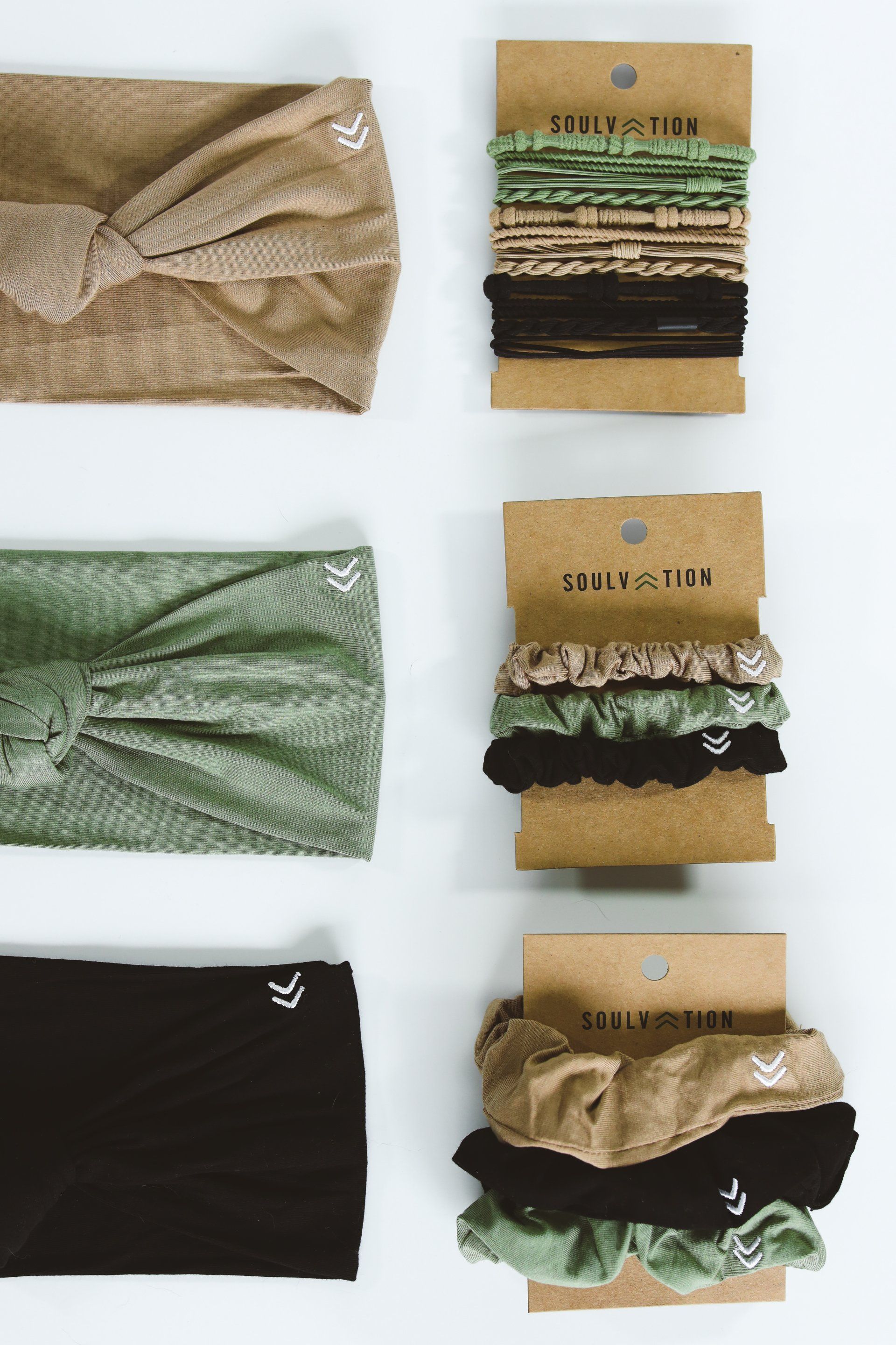 A variety of headbands and scrunchies are lined up on a table.