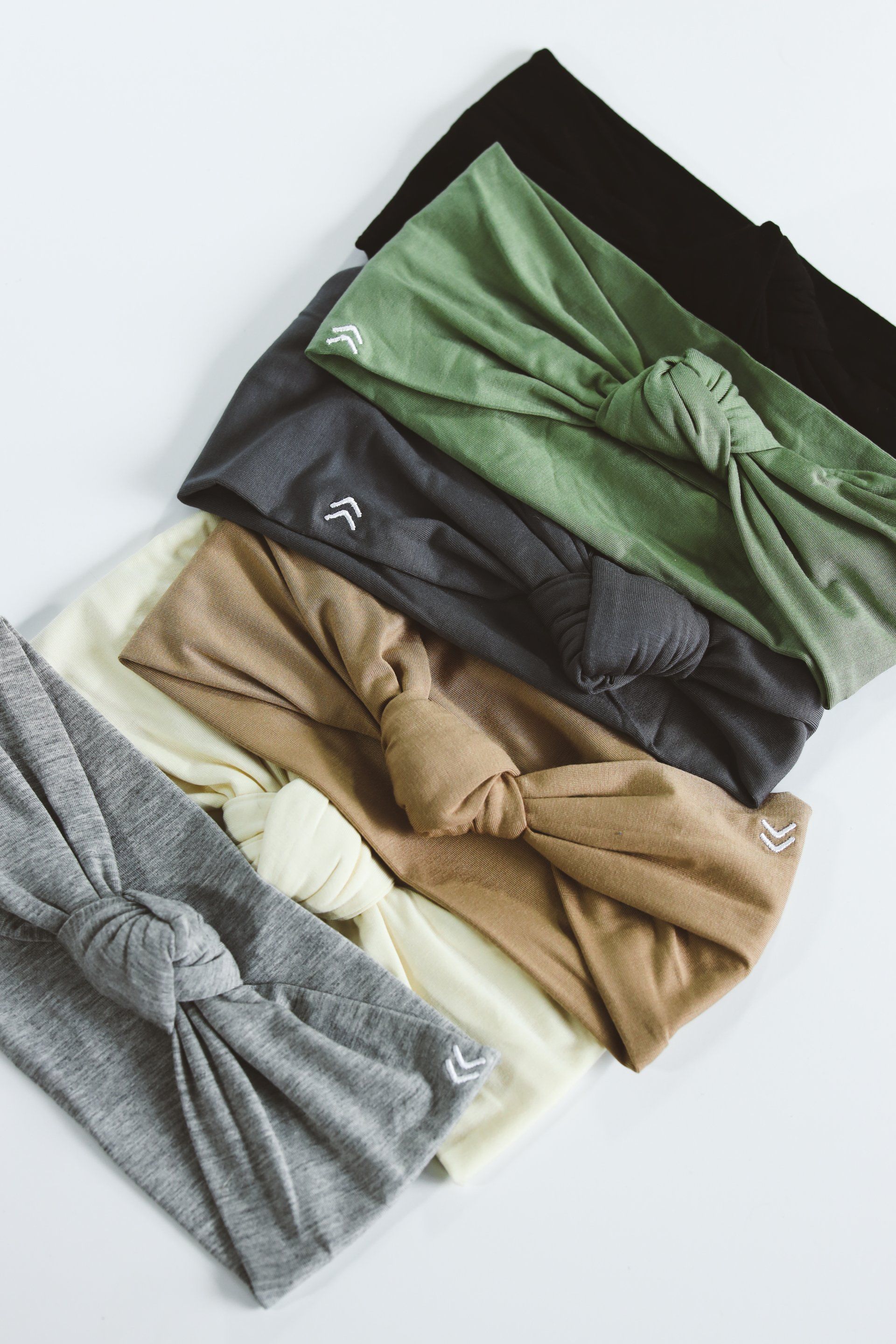 A bunch of headbands are stacked on top of each other on a table.