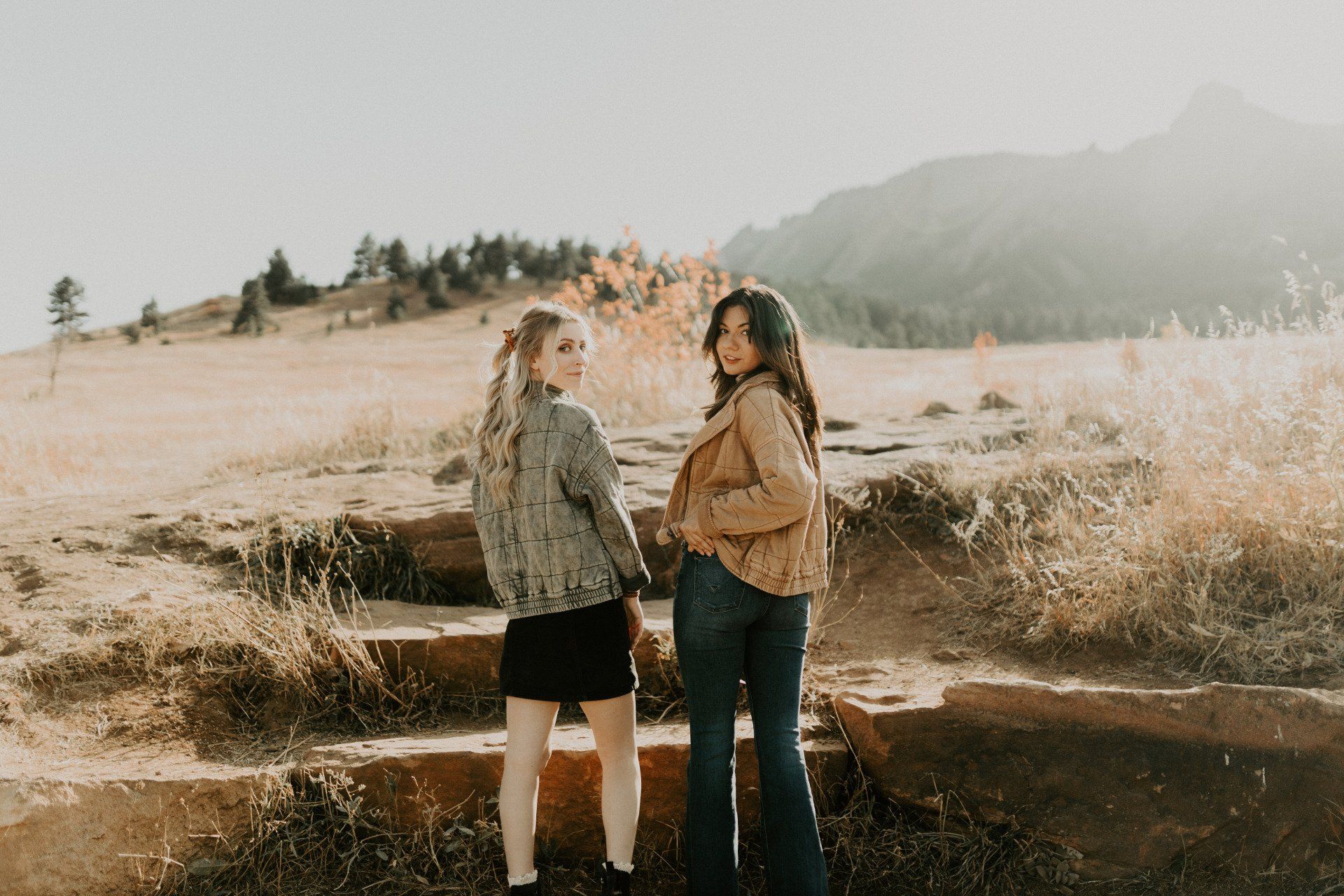 Two women are standing next to each other in a field.