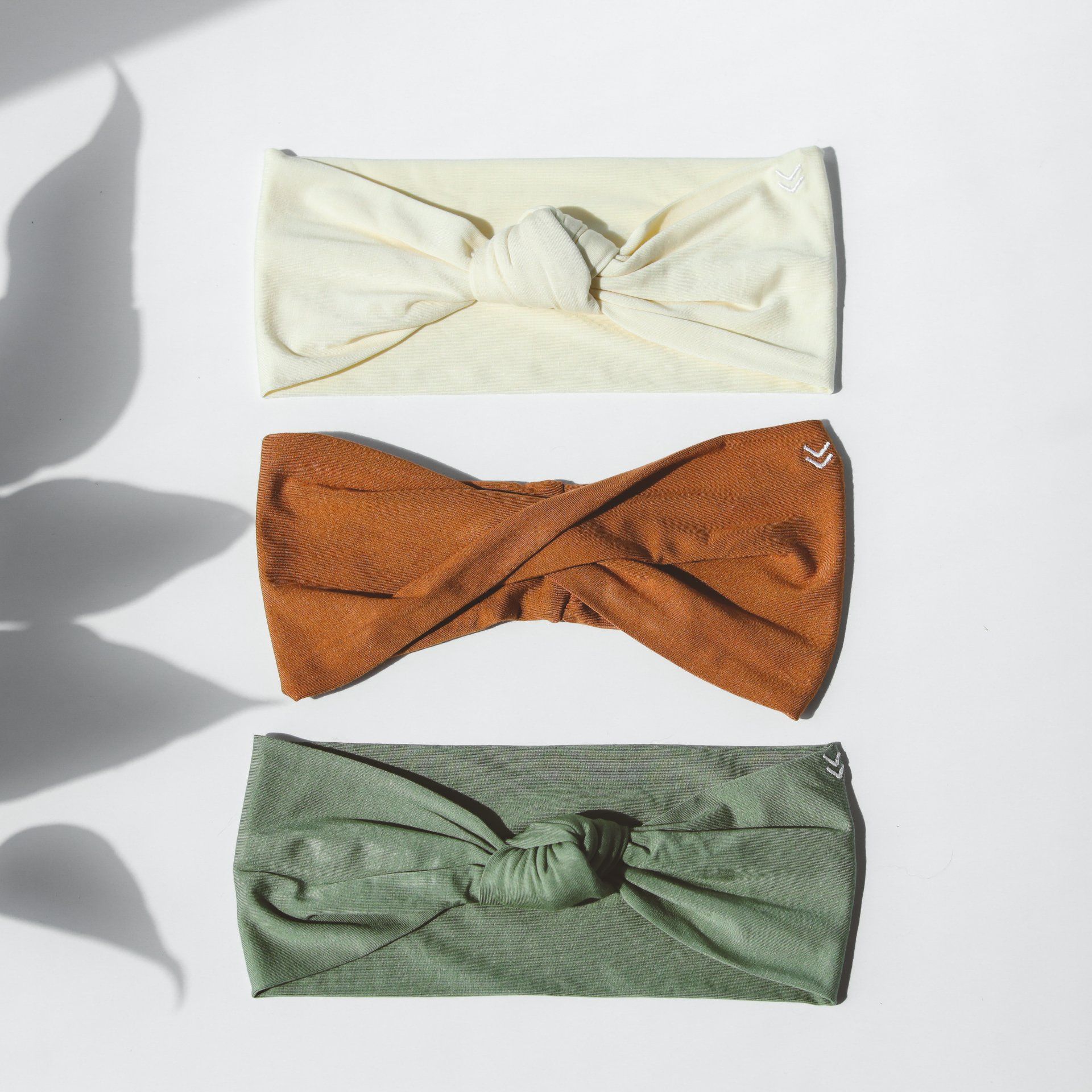 Three different colored headbands are lined up on a white surface