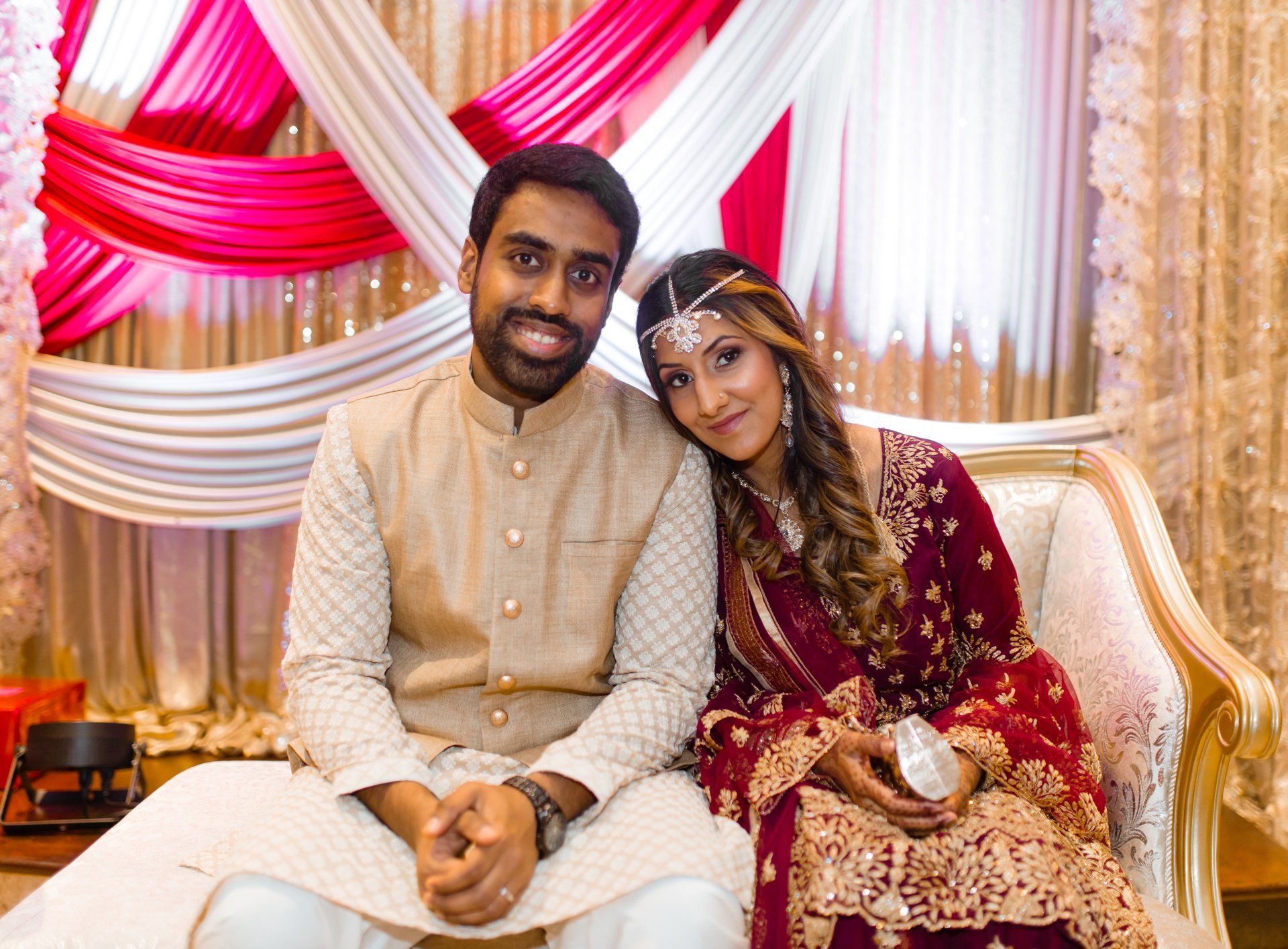 A man and a woman are posing for a picture while sitting on a couch.