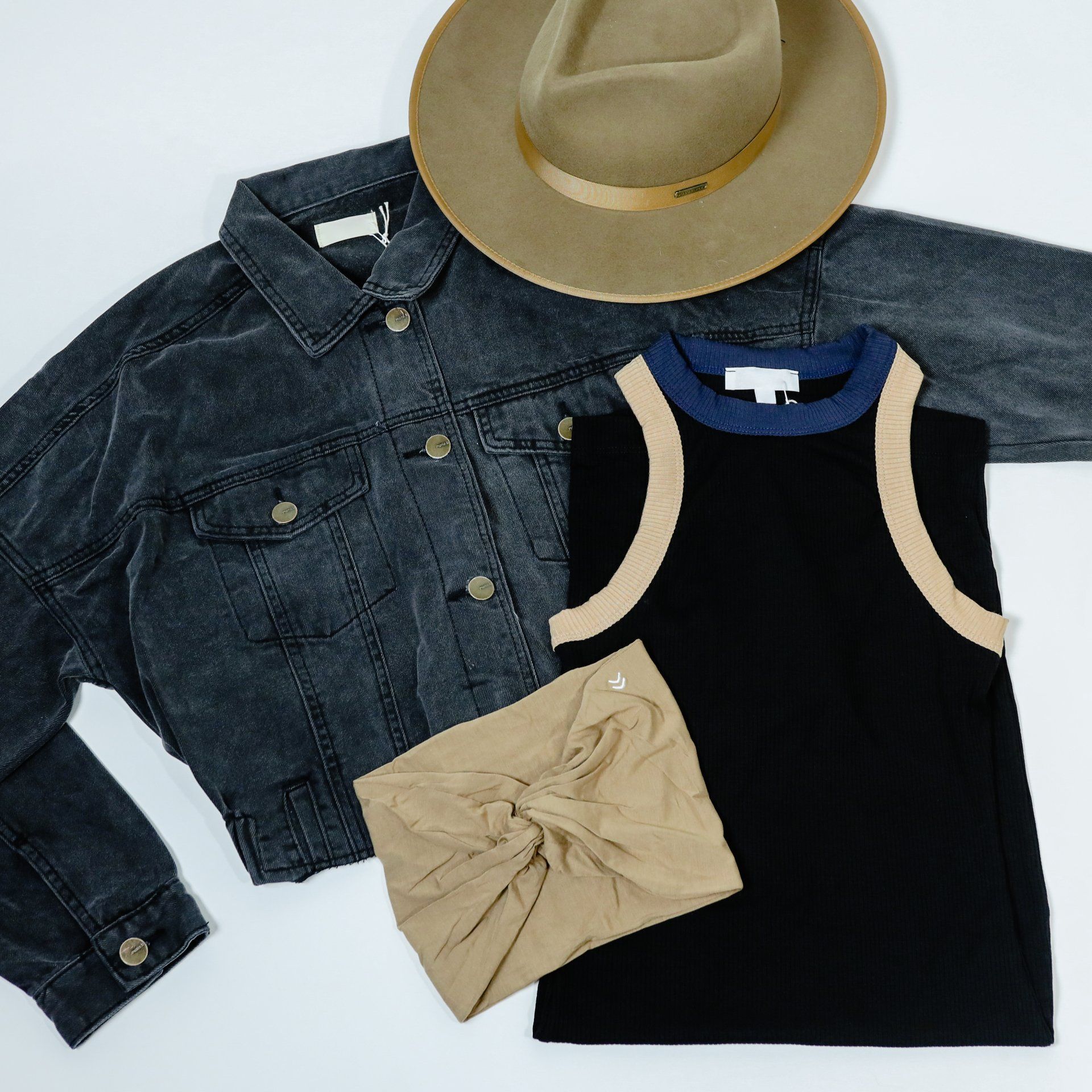 A hat is sitting on top of a denim jacket