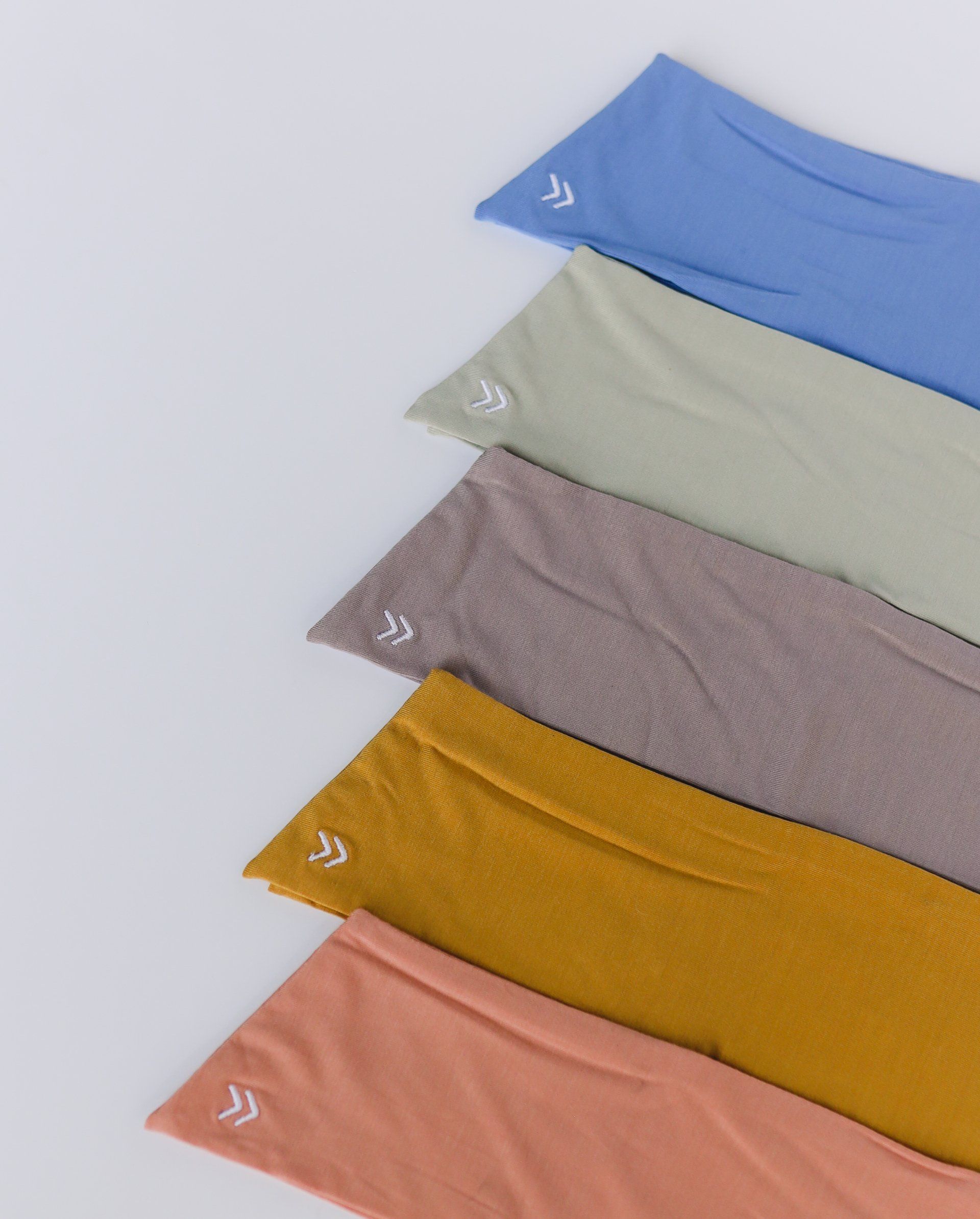 Five different colored shirts are lined up in a row