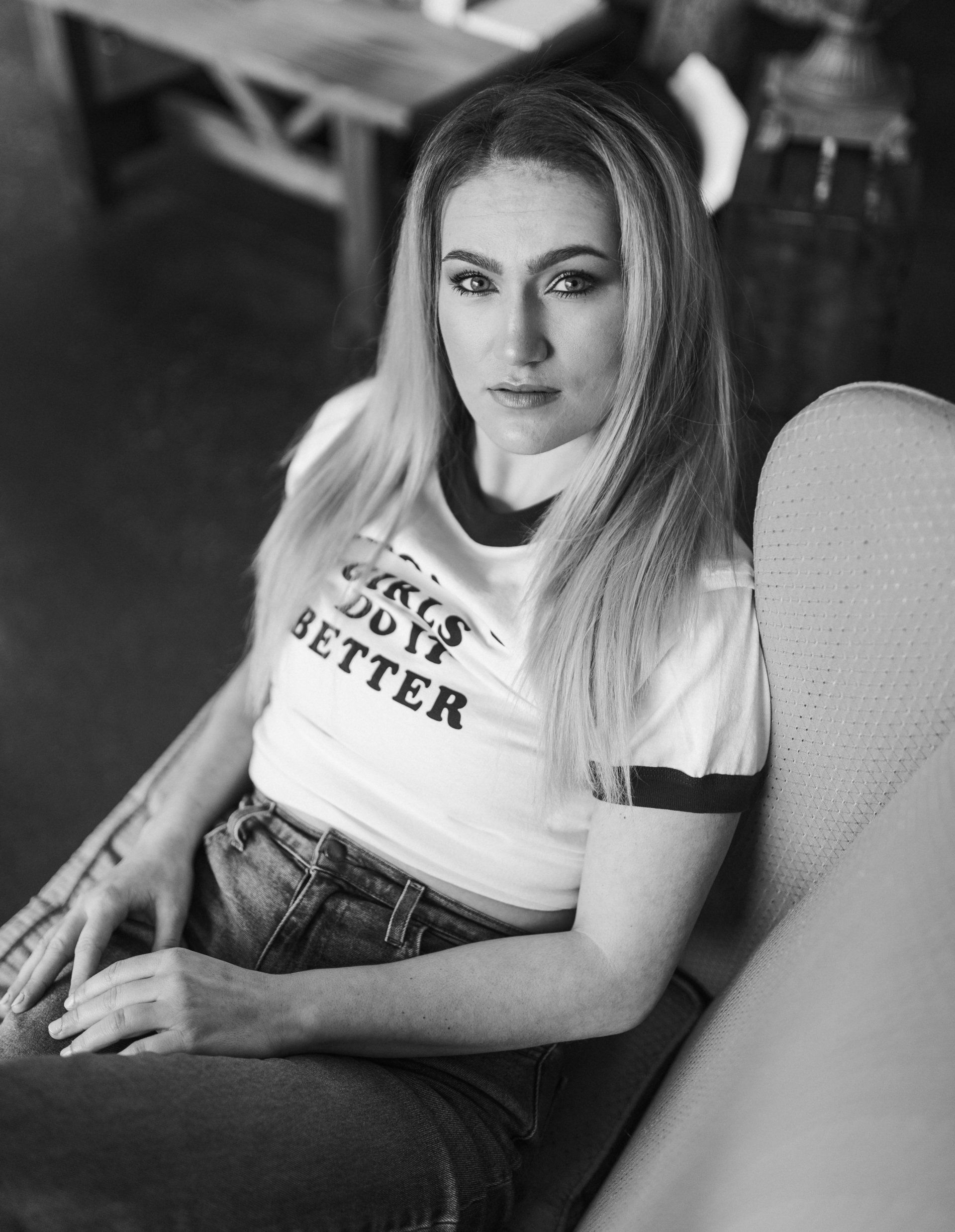 A woman is sitting in a chair wearing a t-shirt that says circus did ya better