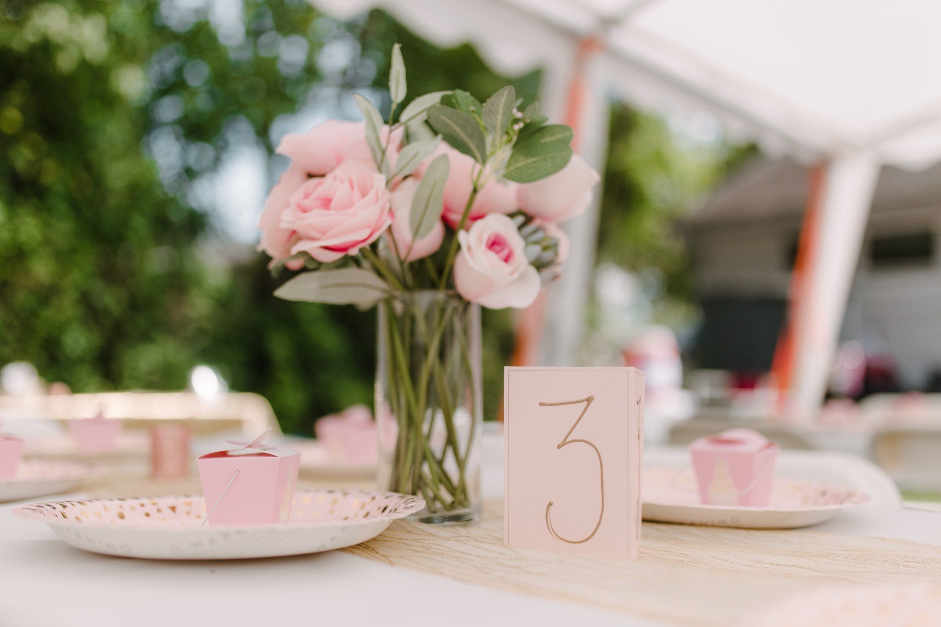 A table with a vase of flowers and a table number on it.