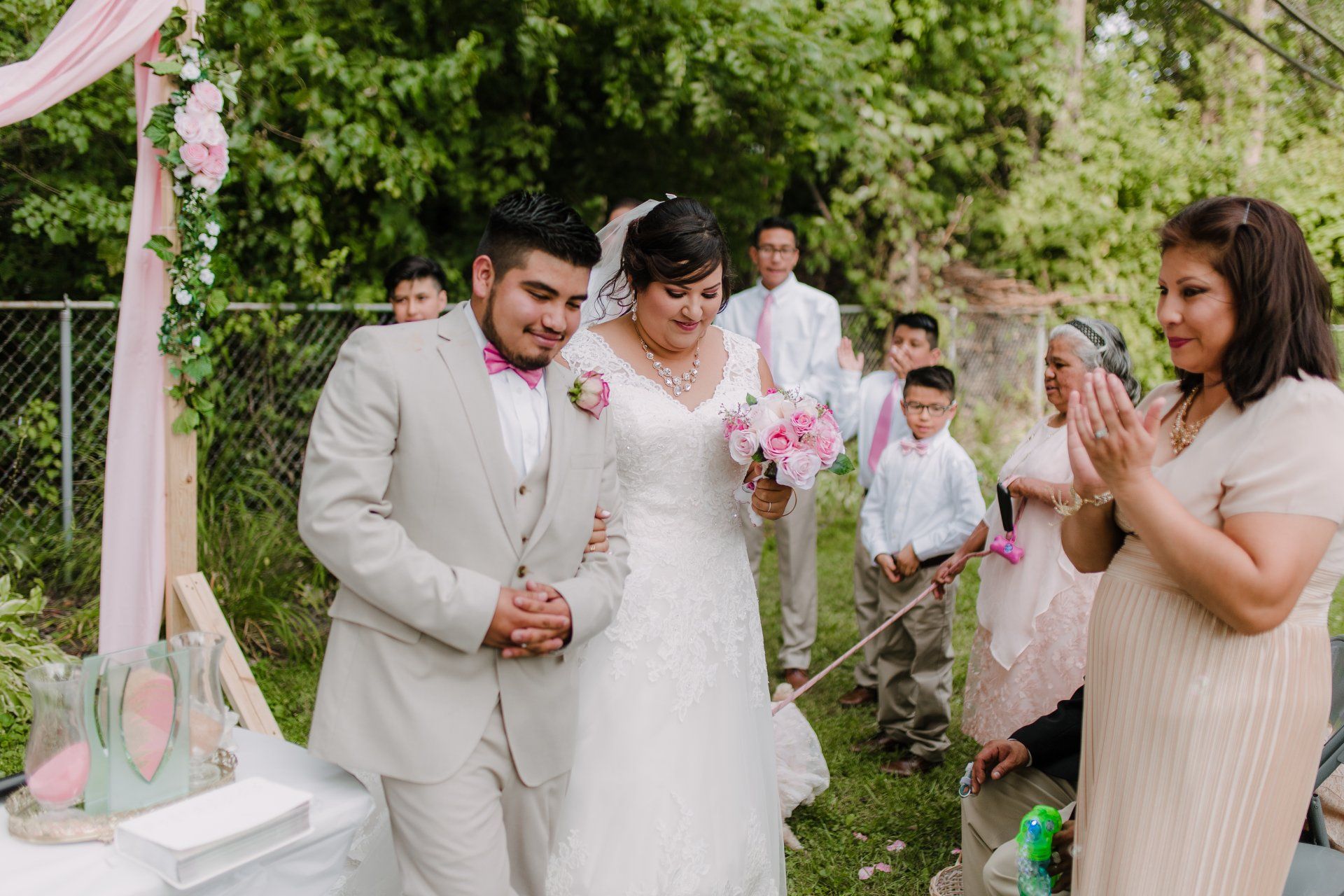 A bride and groom are walking down the aisle at their wedding.