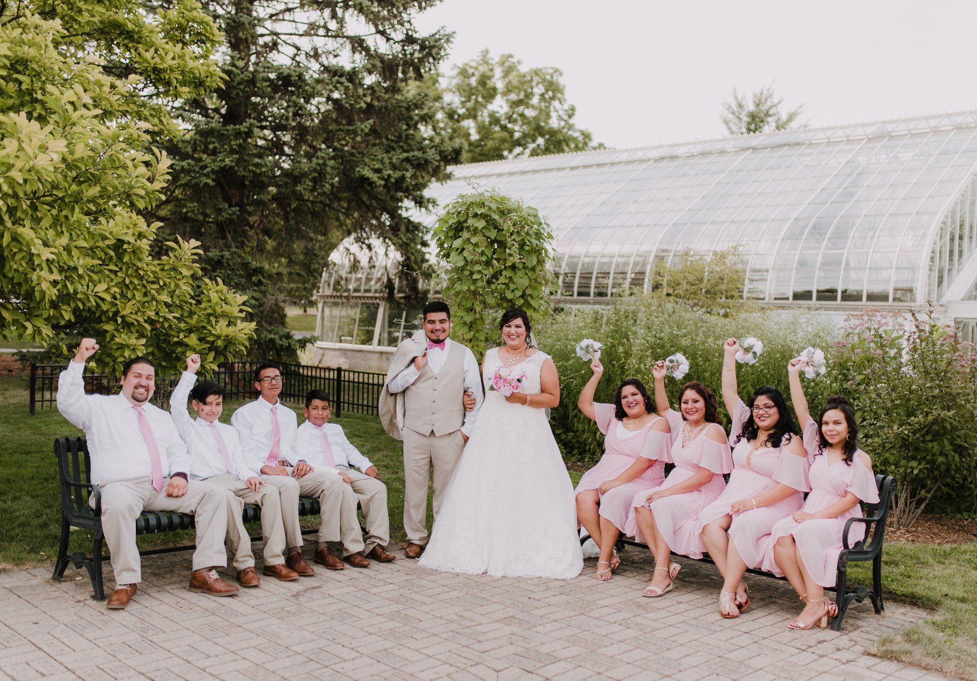 A bride and groom are posing for a picture with their wedding party.