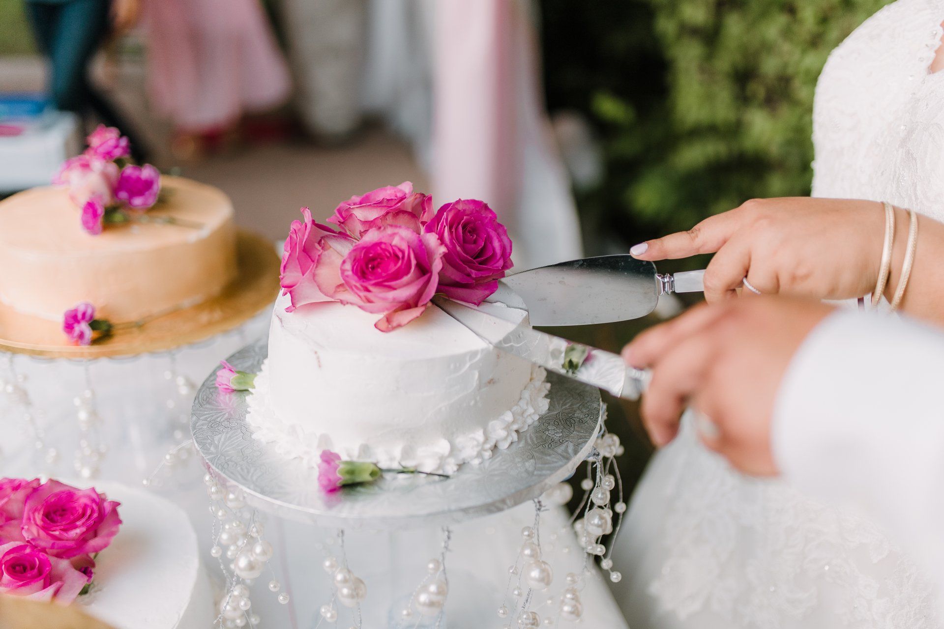 A bride and groom are cutting their wedding cake on a table.