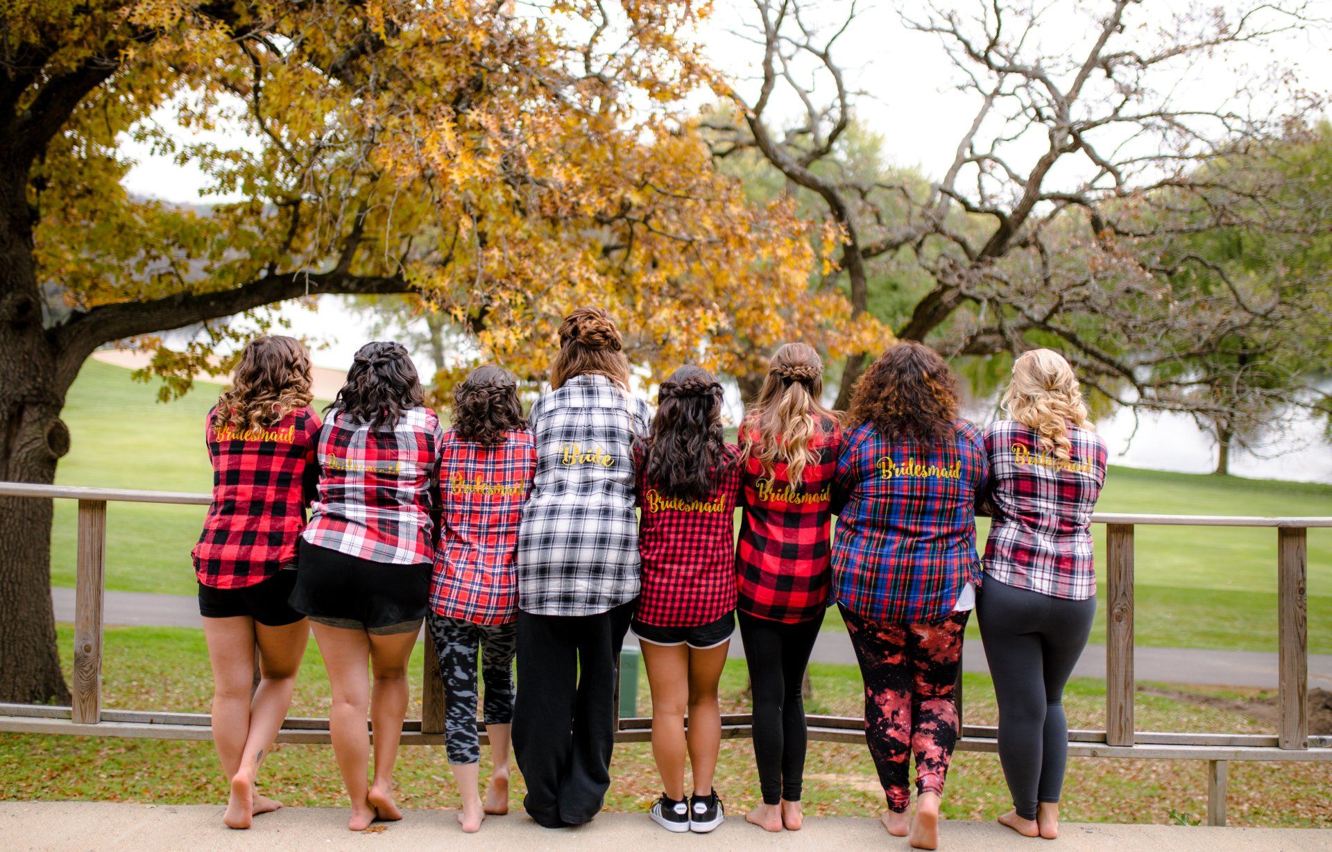A group of women wearing plaid shirts are standing next to each other.