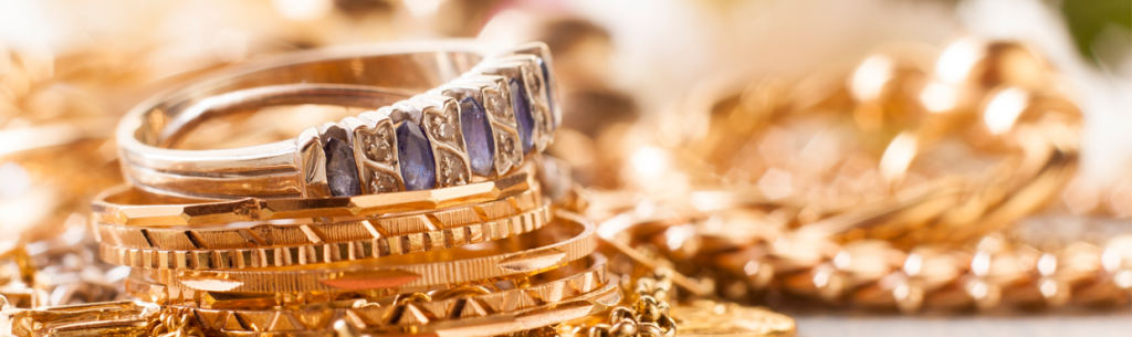 Joyas de oro, incluidos anillos y pulseras, apiladas juntas.