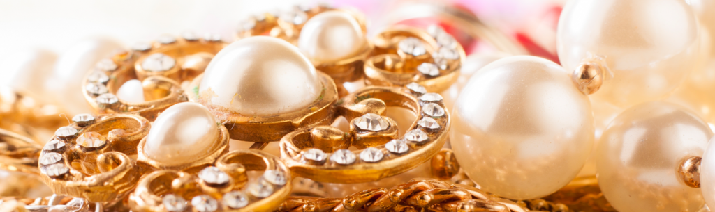 Primer plano de joyas doradas con perlas y adornos.