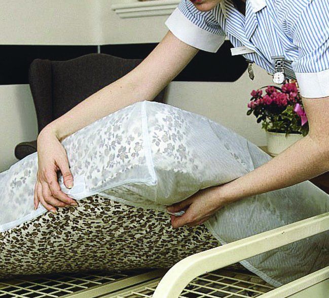 person putting on Waterproof Bedding