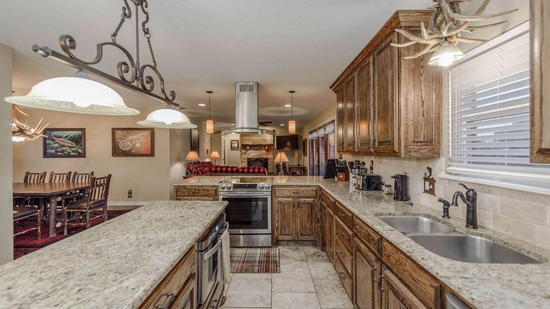 A kitchen with granite counter tops , stainless steel appliances , and wooden cabinets.