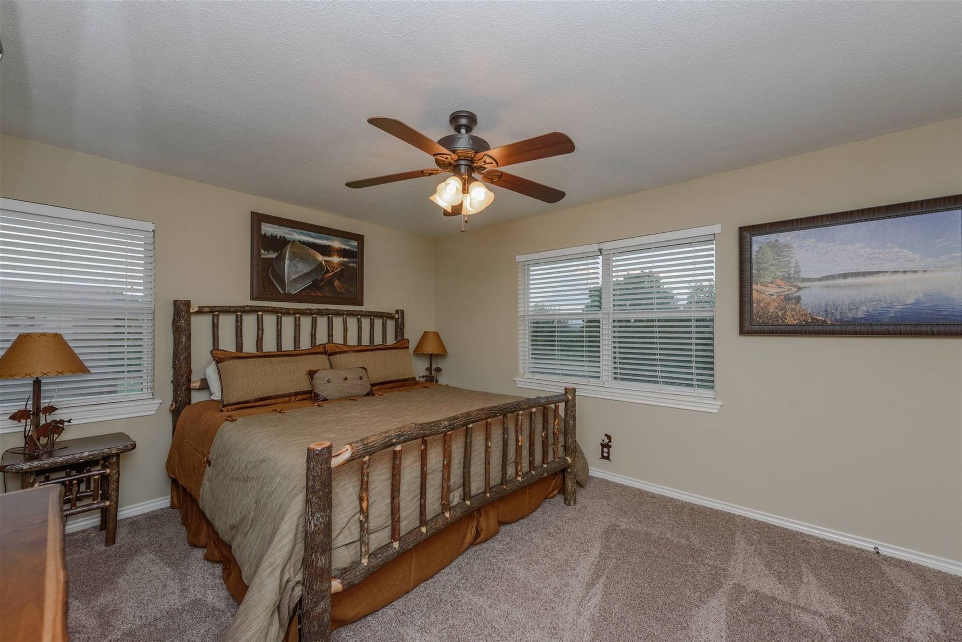 A bedroom with a king size bed and a ceiling fan.
