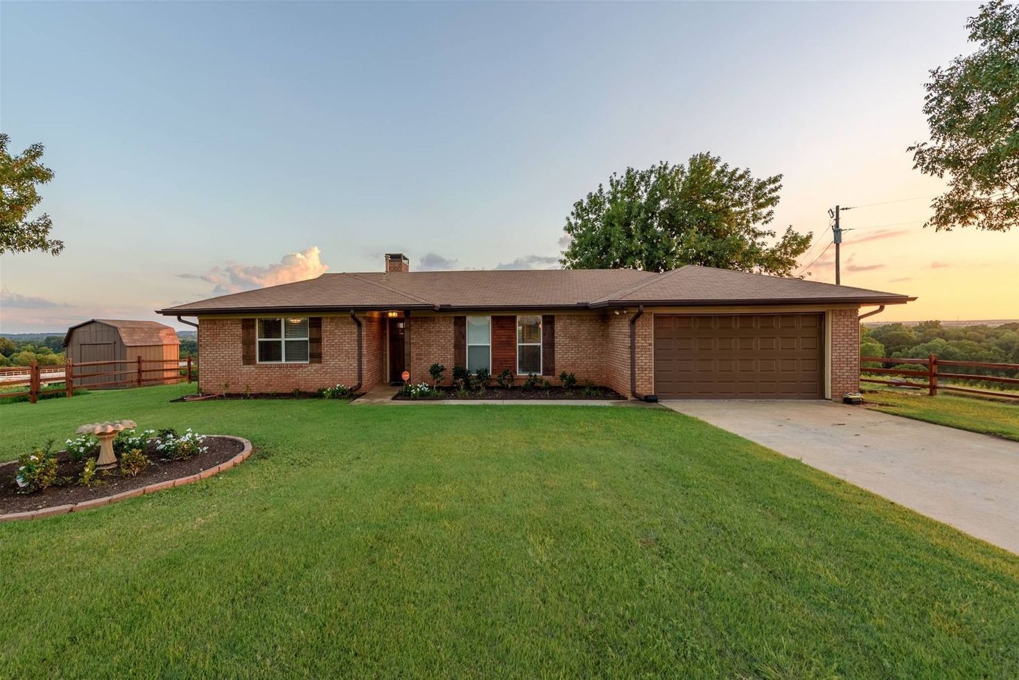 A brick house with a large lawn and a garage