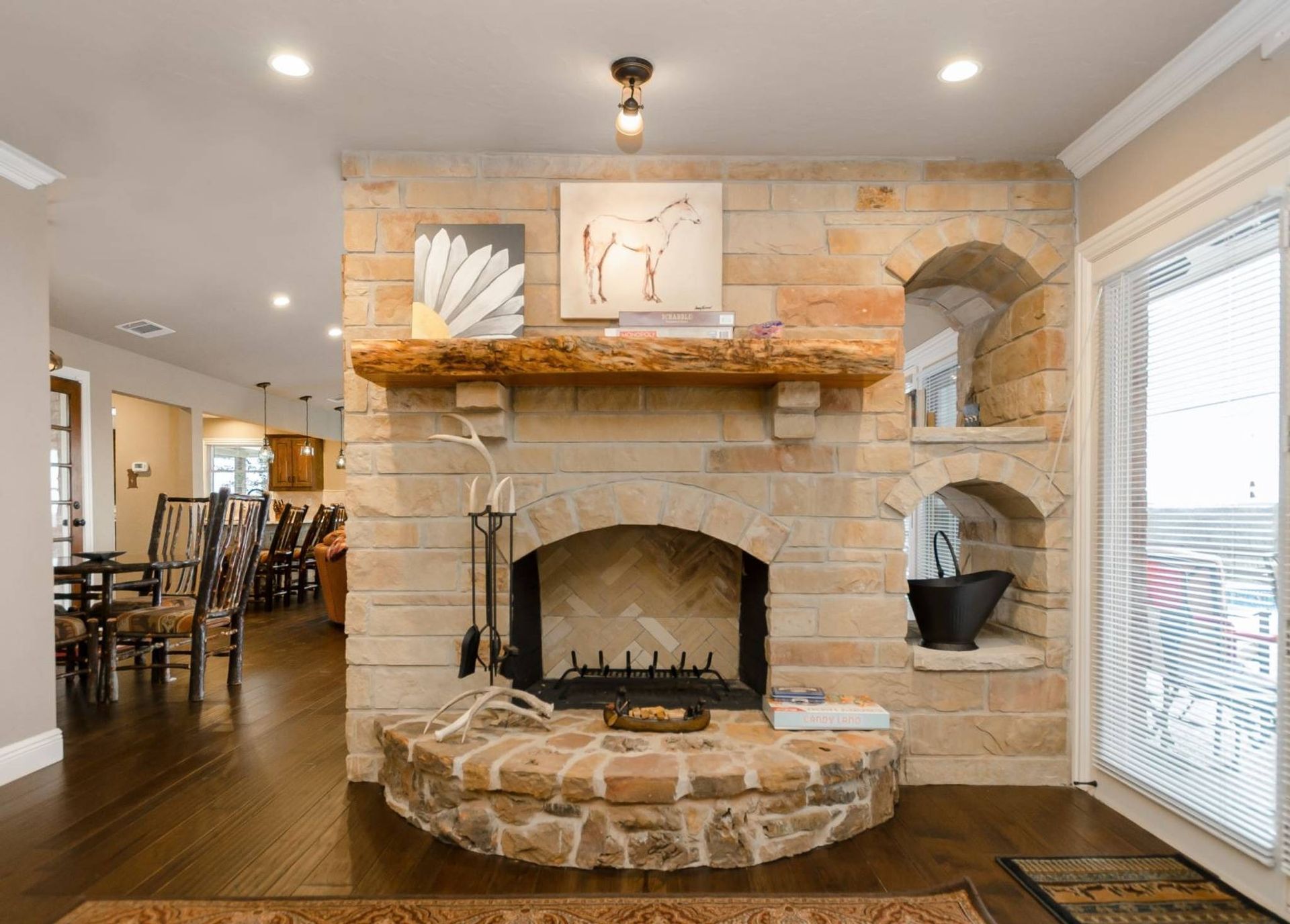 A living room with a stone fireplace and a sliding glass door.