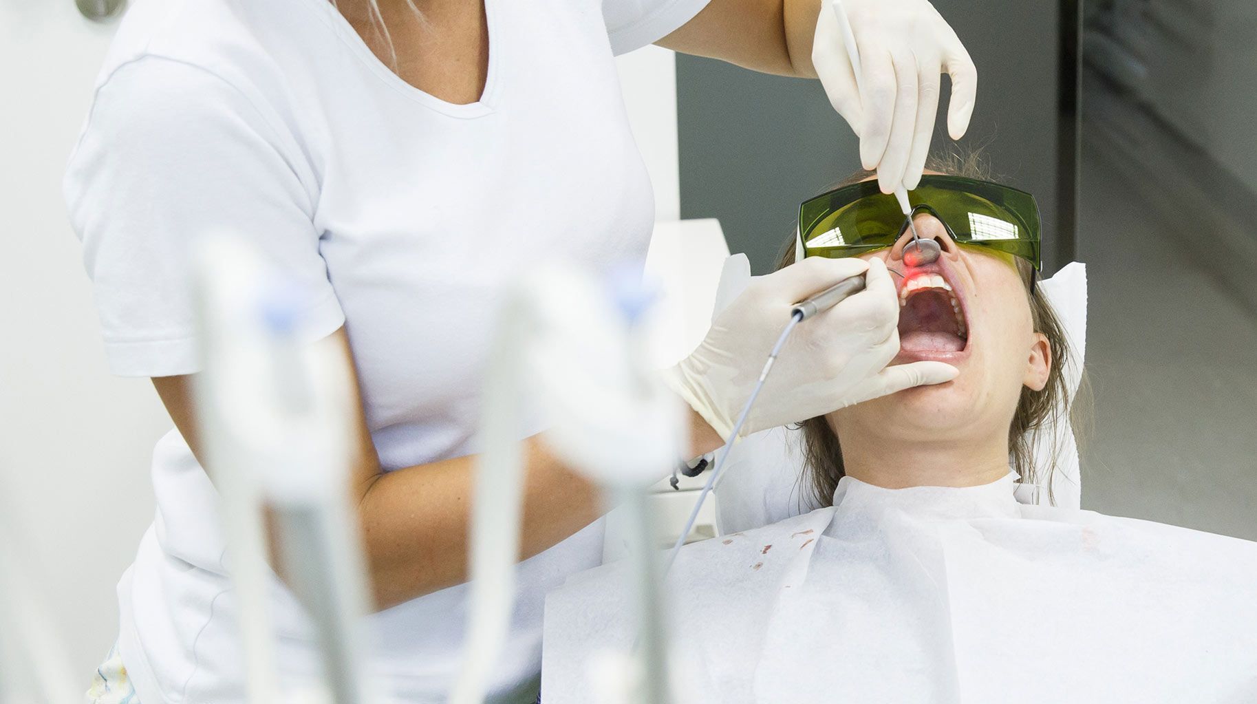 A woman is getting her gums surgically treated with LANAP by her periodontist.