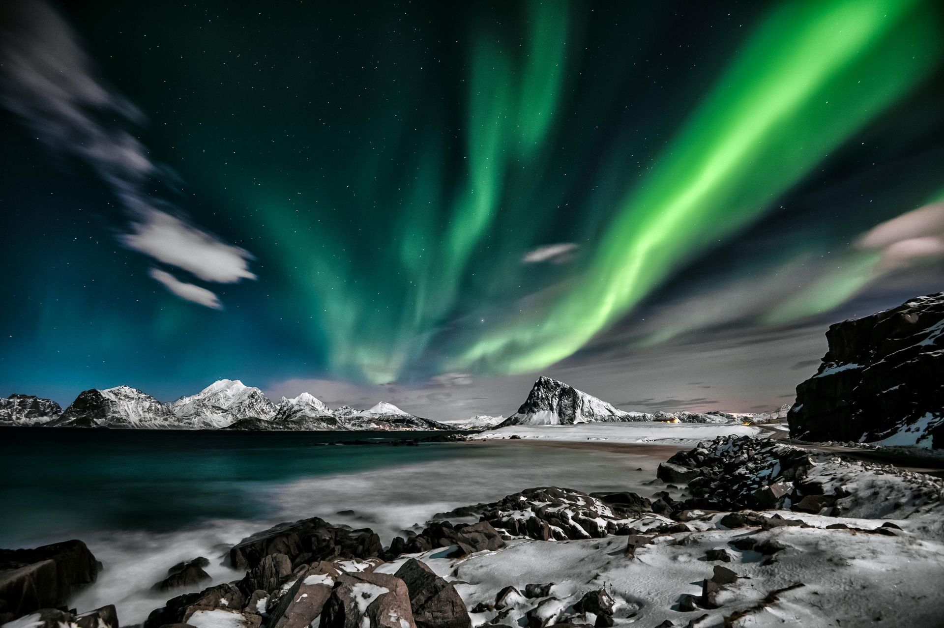 Northern Lights dancing over Norwegian fjord in winter, fantasy travel destination in the Arctic