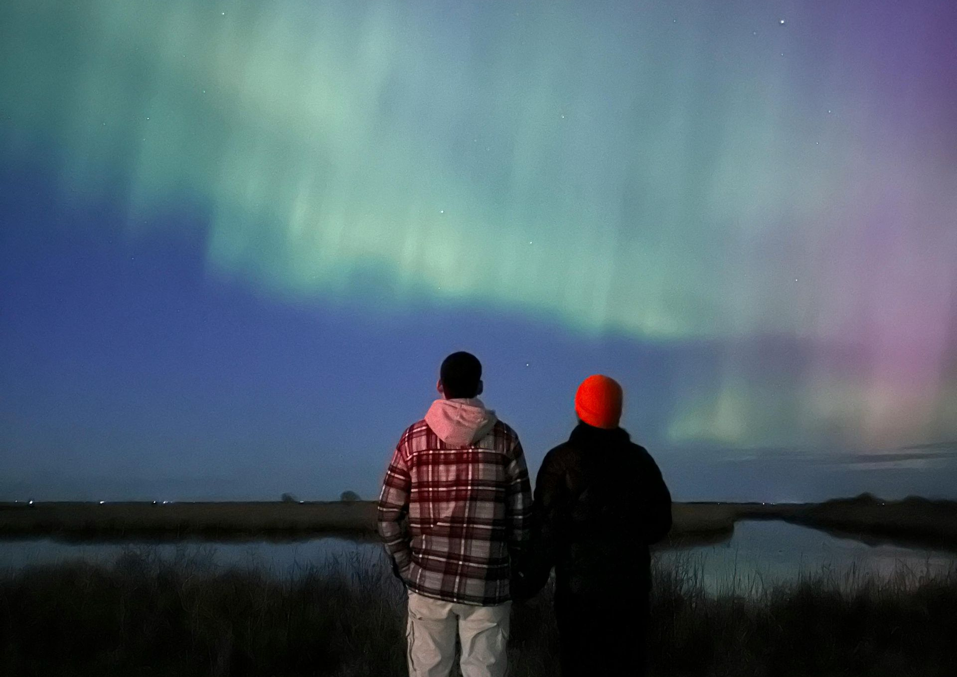Couple enjoying a romantic fantasy honeymoon under the Northern Lights in Norway.
