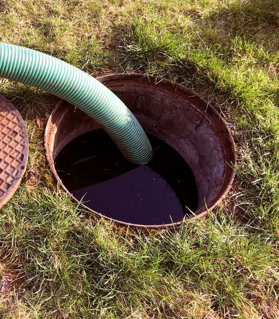 A Green Hose is Inserted Into an Open, Dark Septic Tank — All Class Liquid Waste in Oakey, QLD