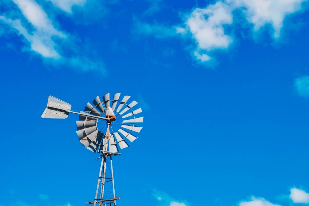 Windmill Against a Bright Blue Sky With Scattered White Clouds — All Class Liquid Waste in Gatton, QLD