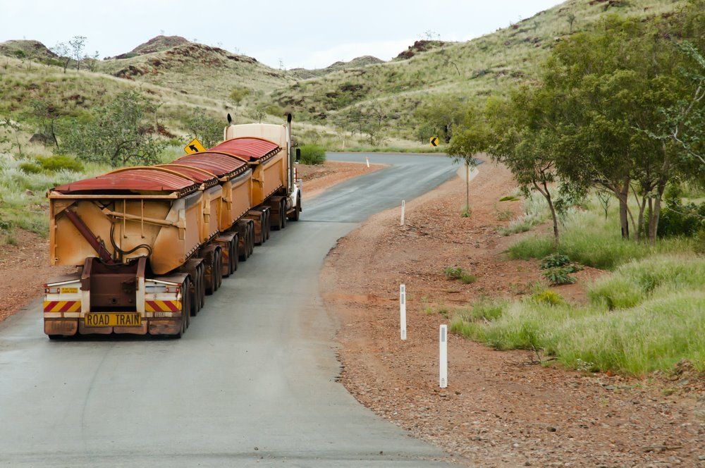 A Large Truck Hauling Multiple Trailers Filled With Cargo — Cadillac Transport Repairs in Winnellie, NT