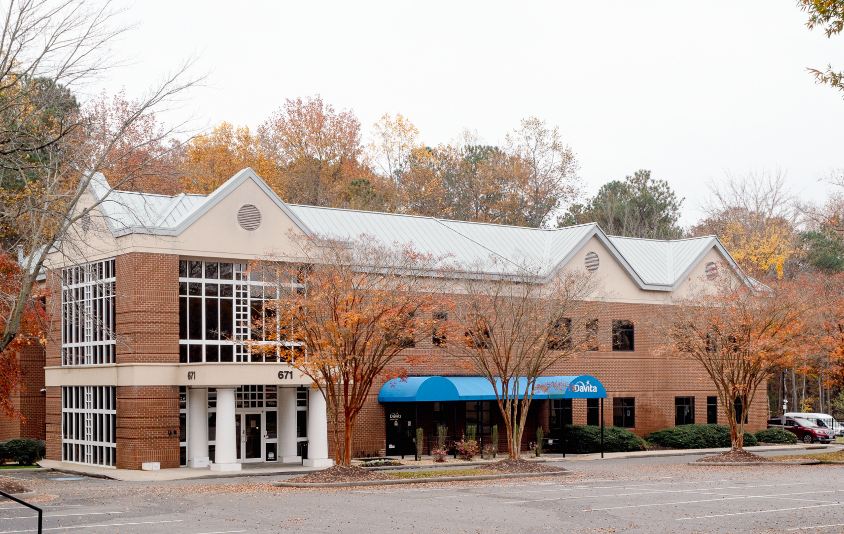 A white building with a blue awning and the word davita on it