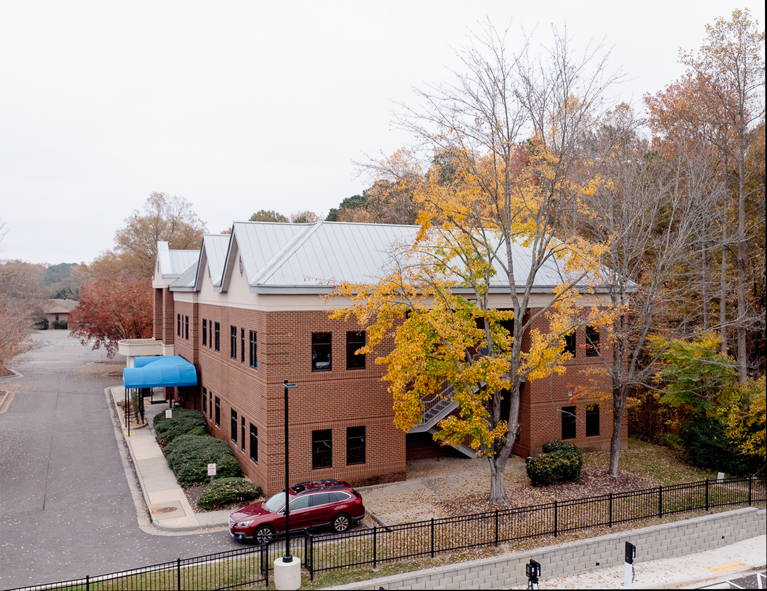 Two-story davita dialysis & richmond nephrology brick building with a silver roof and blue awning.