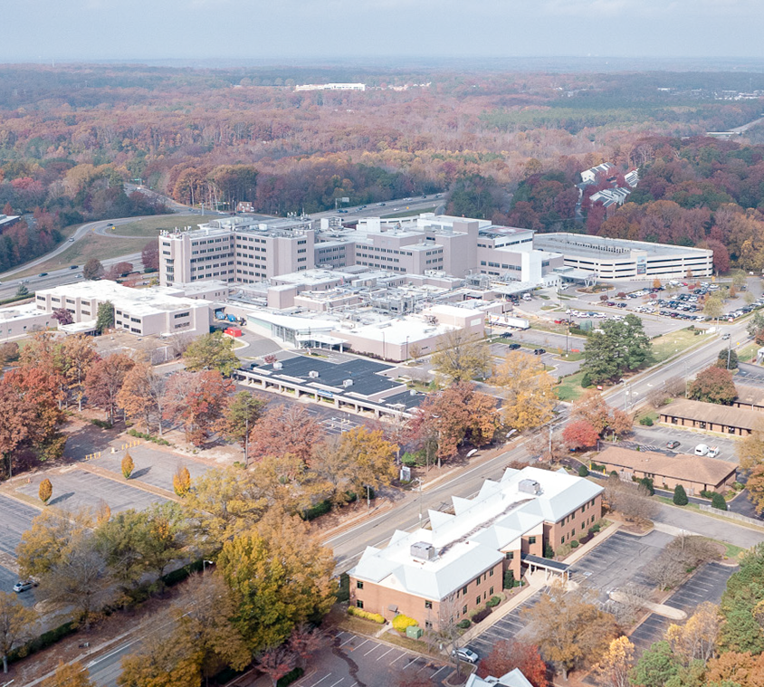 Aerial view of a large hospital complex surrounded by fall foliage, with an adjacent davita dialysis & richmond nephrology building.