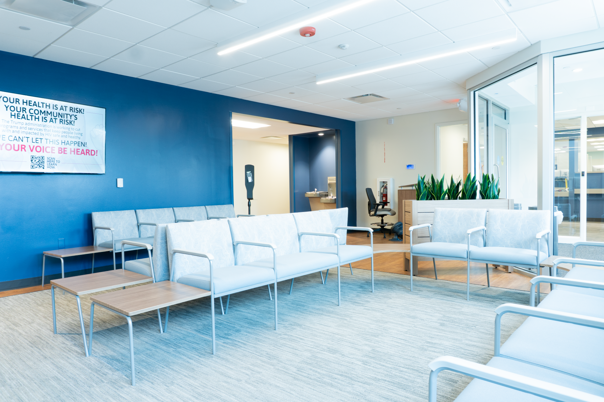 Absolute net medical Vivent Health lobby room with blue wall, light gray chairs, and indoor plants.