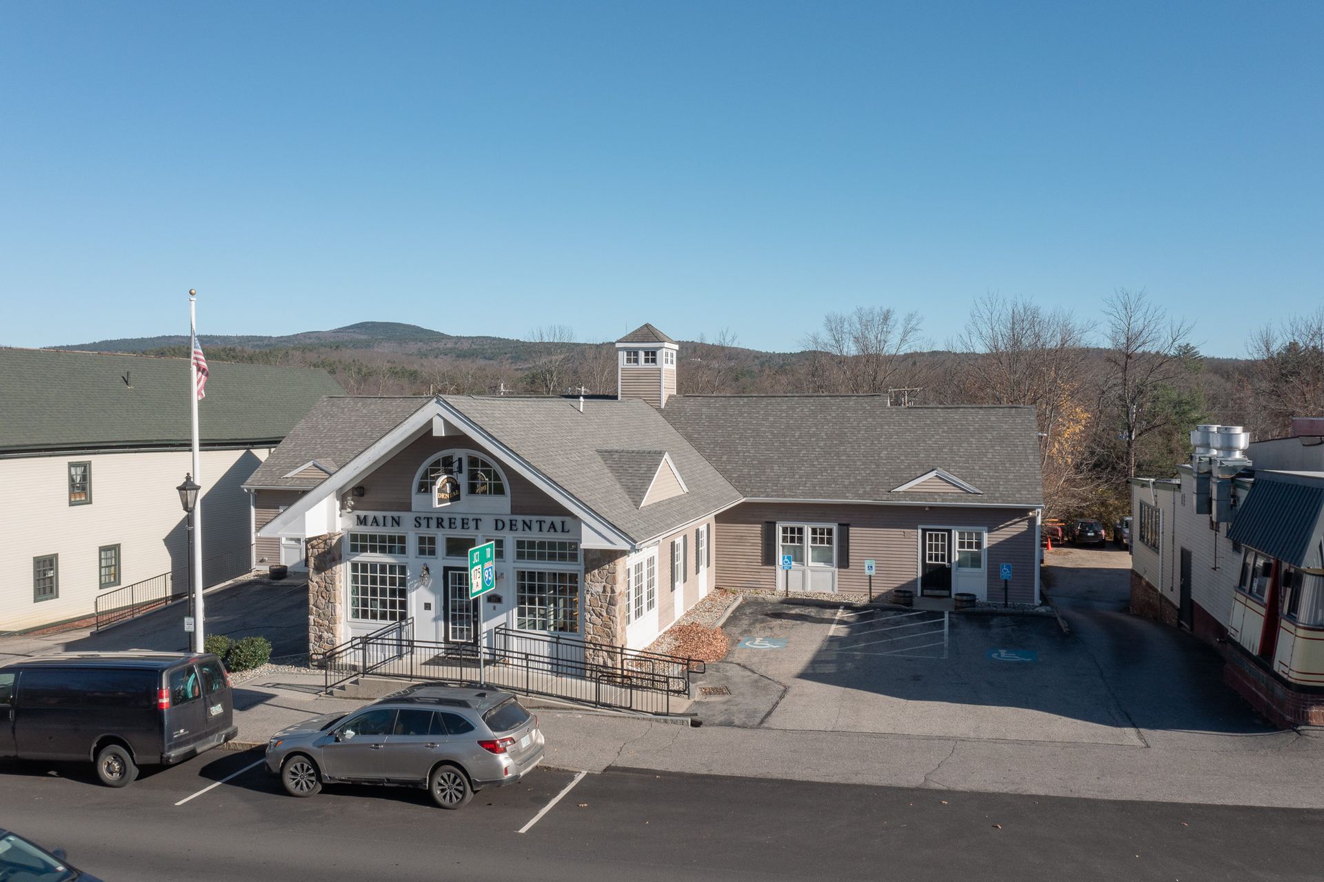 Exterior view of the North Conway Public Library, with cars parked in front and mountains in the background.