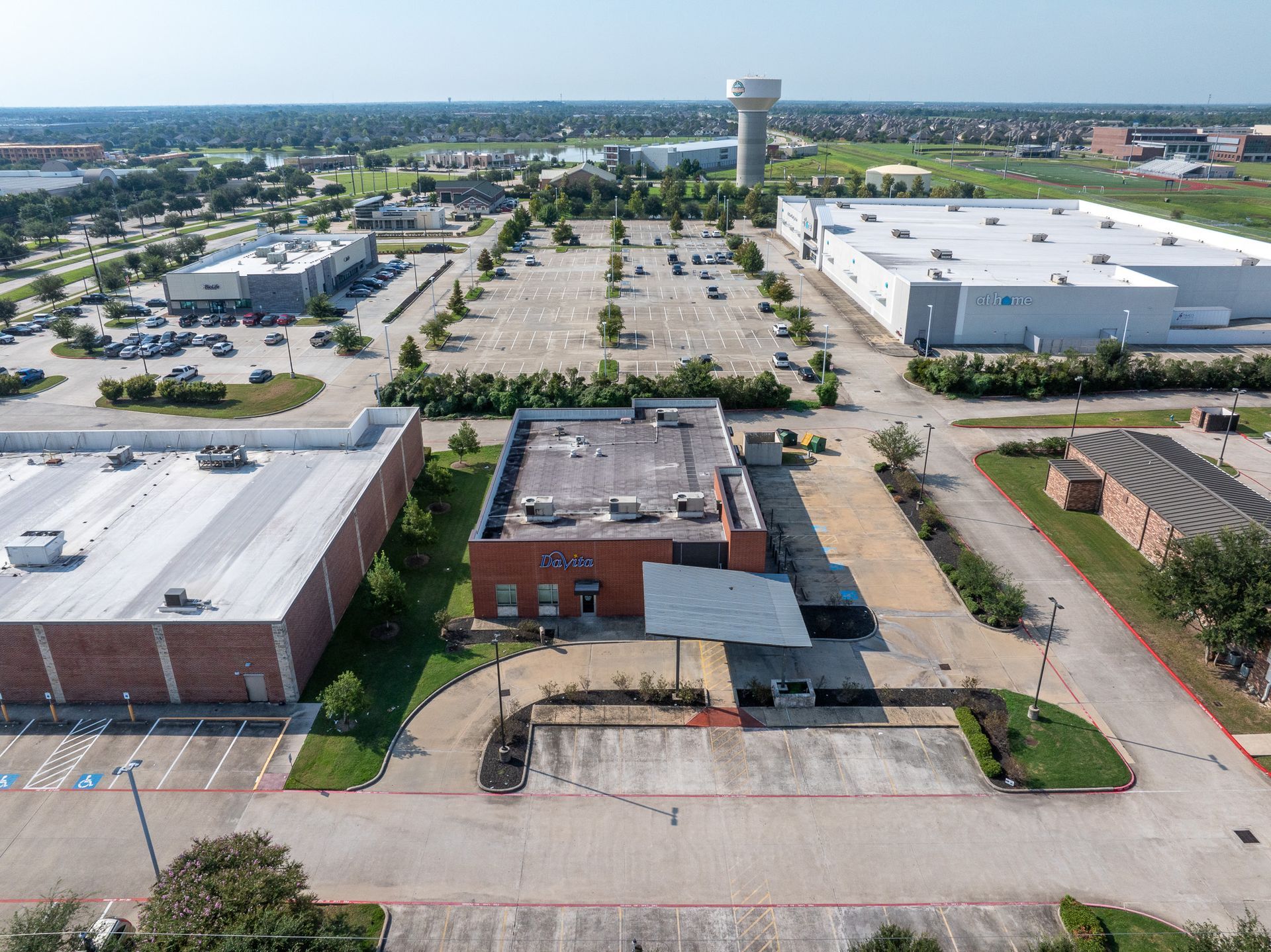Aerial view of industrial buildings, parking lots, and a water tower in pearland texas.