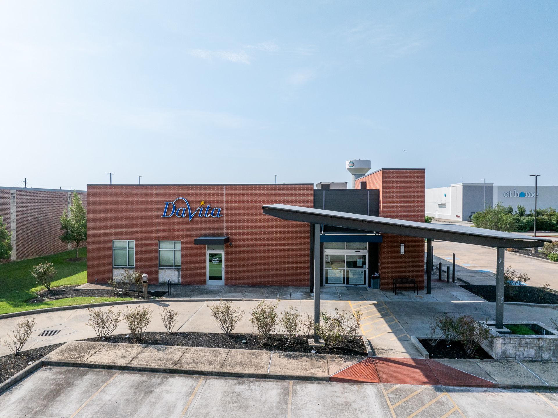 Davita dialysis building with a blue sign, covered entryway, and parking lot.
