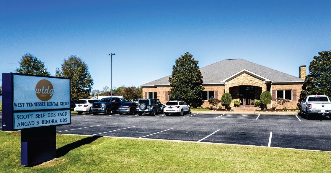 A brick building with a lot of cars parked in front of it.