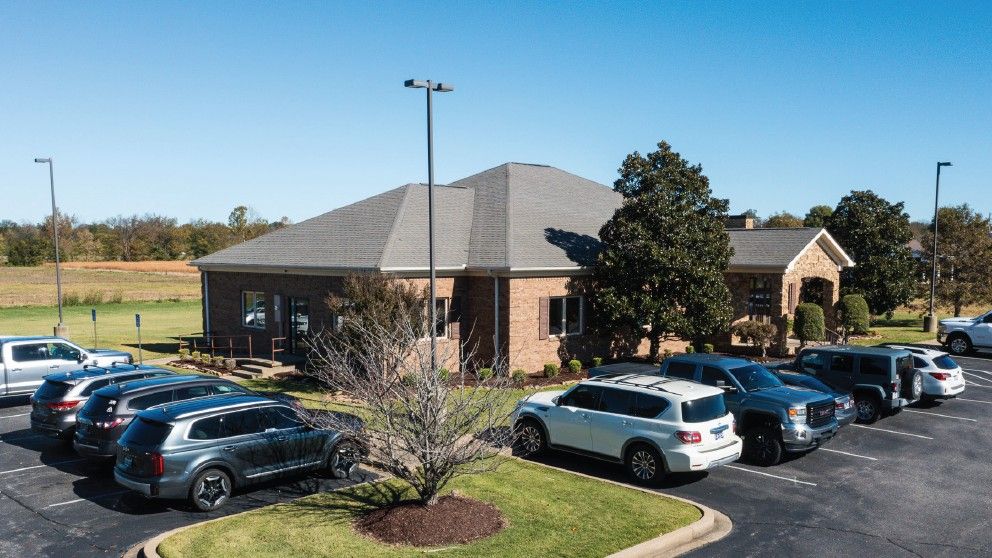 A lot of cars are parked in front of a building.