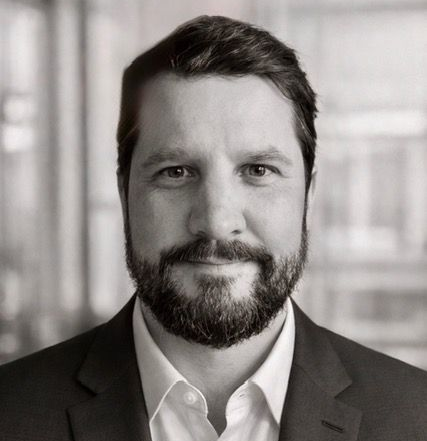 Harrison Warr smiles at the camera against a plain background.