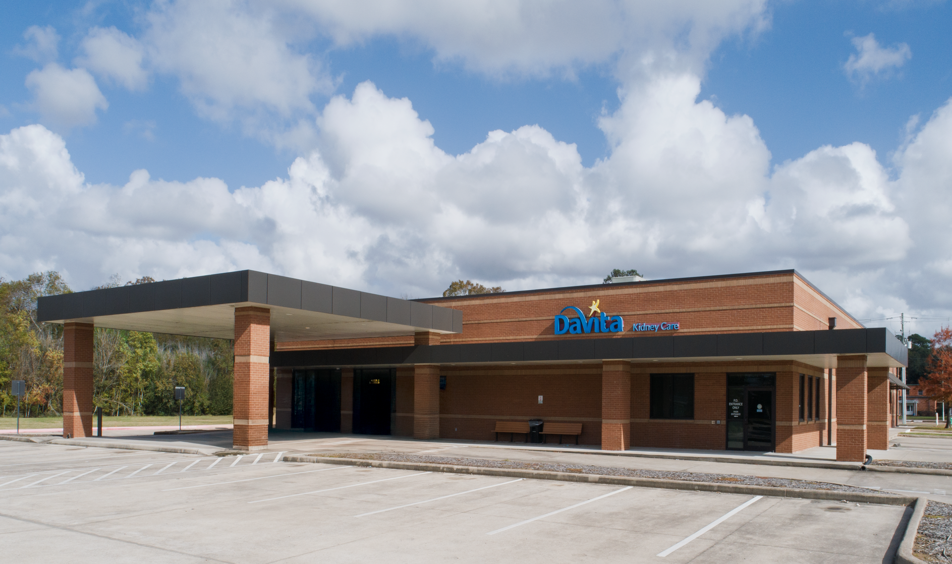 A white building with a blue awning and the word davita on it