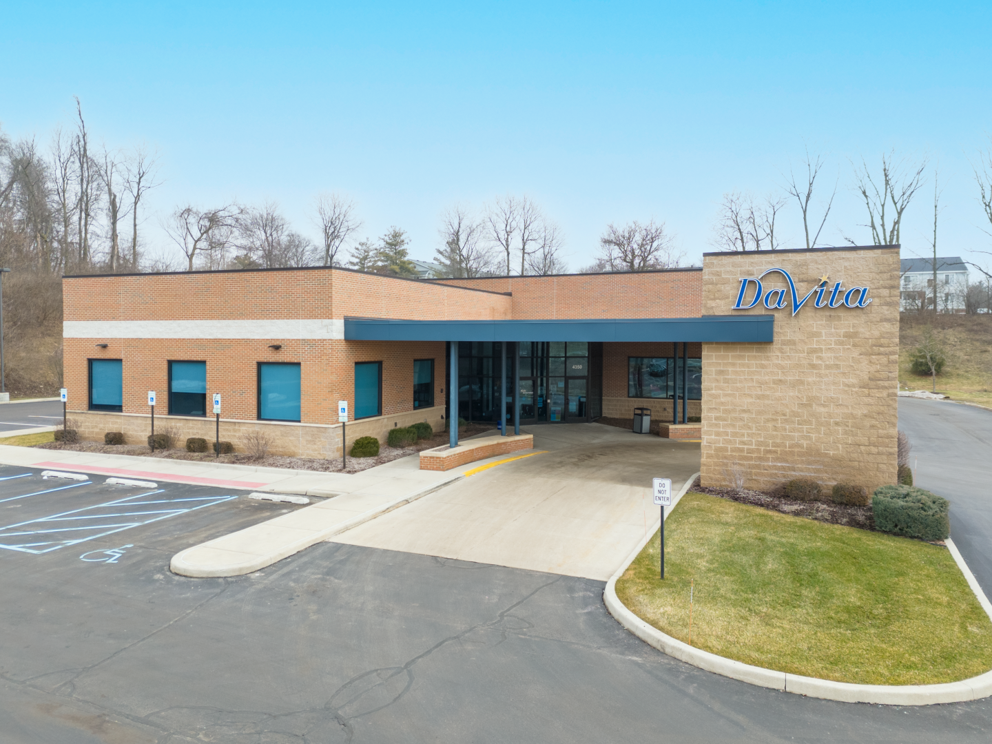 A white building with a blue awning and the word davita on it