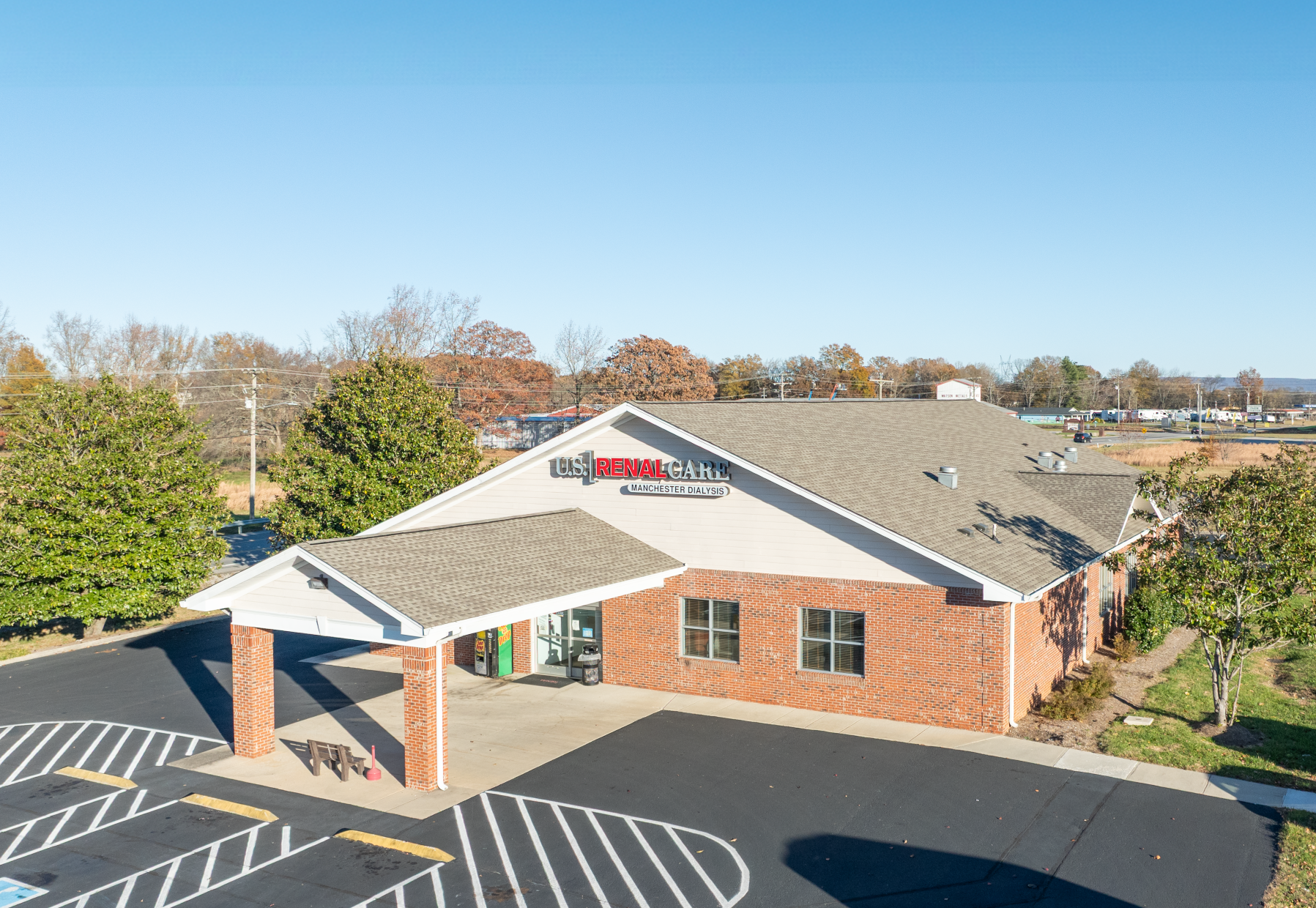 US Renal Care dialysis clinic building with a covered entrance, red brick exterior, and a parking lot.