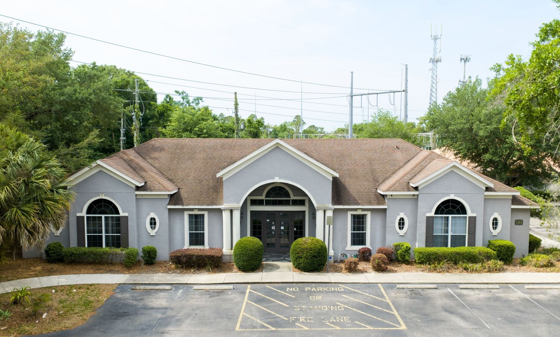 Pediatric Associates single-story office building in Longwood, FL with arched windows, tan roof, and parking lot in front
